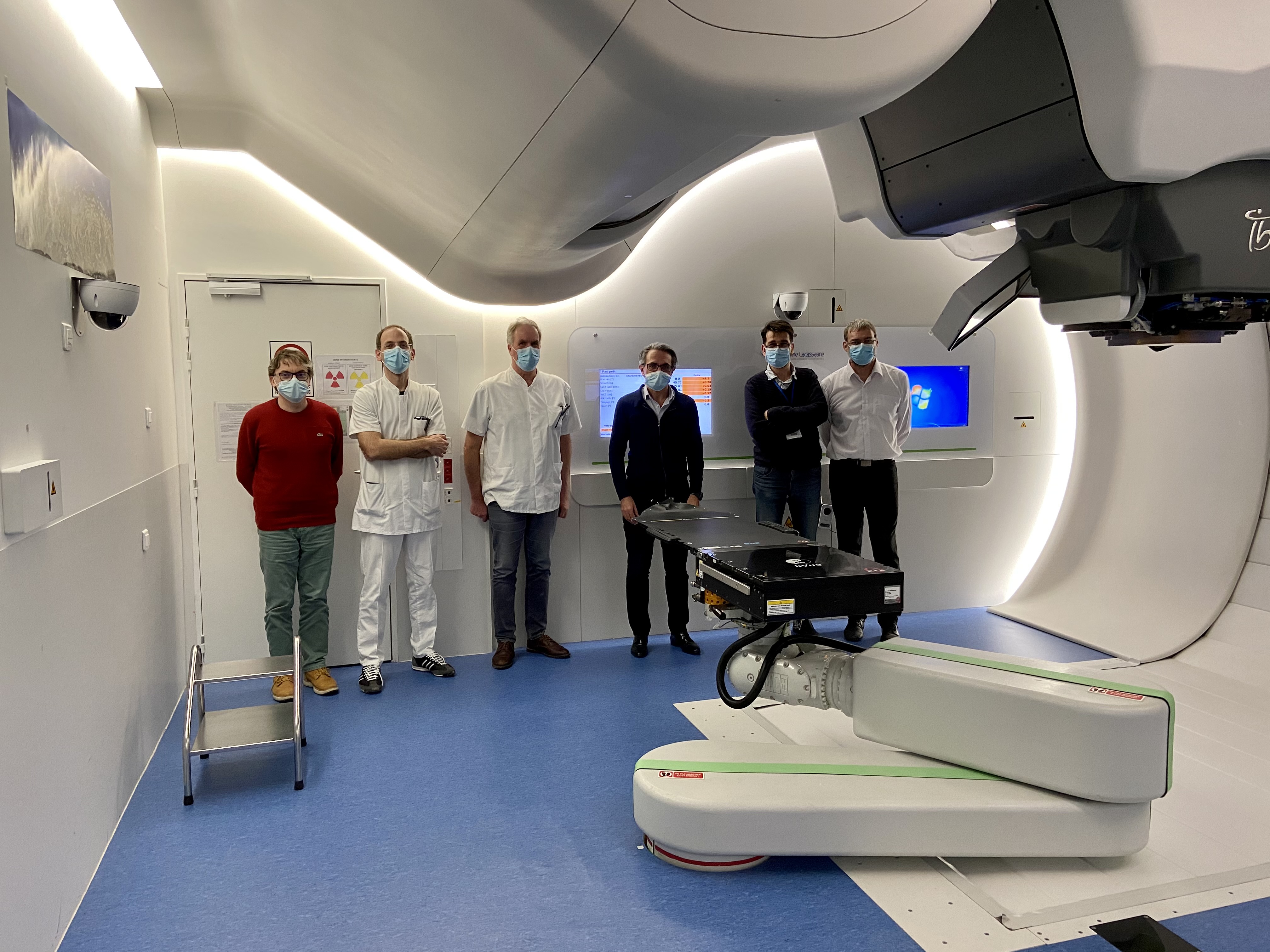 Photo de groupe (6 personnes) de la collaboration IN2P3 / CAL. Les personnes se tiennent dans une salle contenant du matériel d'imagerie médicale
