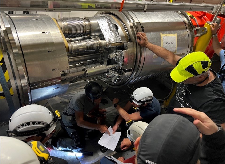 Vérification et réparation de l'interconnexion fissurée qui relie deux triplets (orange) du LHC.